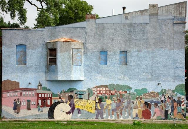 A mural of a parade on the side of a building
